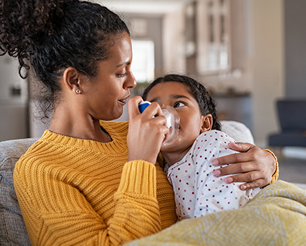 Mother Helping Her Baby Girl, Who Suffers From Asthma, Breathe Through a Nebulizer