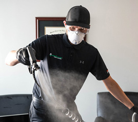 A Technician Spraying the Genesis HOCl Solution Which is a Broad Spectrum Sanitizer and Disinfectant Treatment