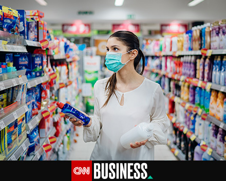 Image of a woman at the supermarket choosing a cleaning product