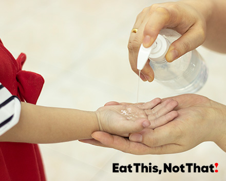 Image of a woman putting hand sanitizer in a childs hand