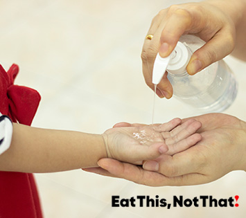 Image of a woman putting hand sanitizer in a child hand