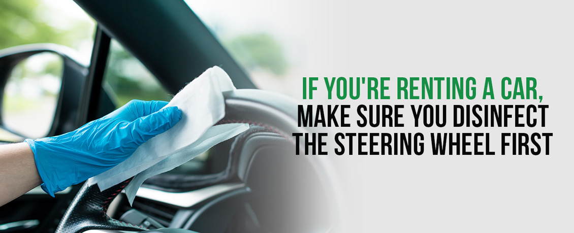 A Person Who Rented a Car Making Sure the Steering Wheel Is Disinfected