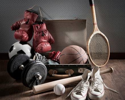 A Set of Dumbells, Baseball and Bat, Tennis Racket, Basketball, Boxing Gloves and Sneakers on the Floor